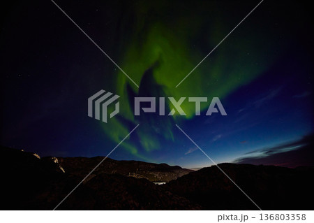 Aurora borealis over ocean in Teriberka, Russia, Murmansk region, Northern lights, Starry sky with polar lights and clouds. Night autumn landscape with bright aurora, stars, sea 136803358