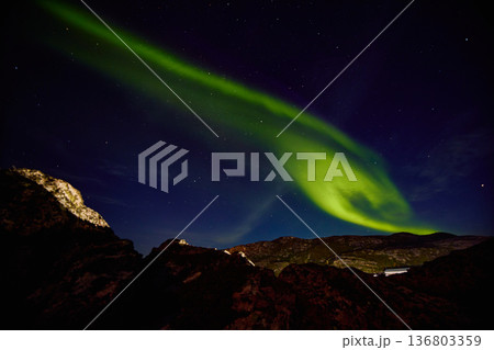 Aurora borealis over ocean in Teriberka, Russia, Murmansk region, Northern lights, Starry sky with polar lights and clouds. Night autumn landscape with bright aurora, stars, sea 136803359