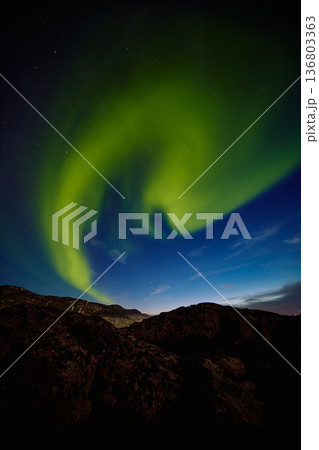 Aurora borealis over ocean in Teriberka, Russia, Murmansk region, Northern lights, Starry sky with polar lights and clouds. Night autumn landscape with bright aurora, stars, sea Aurora borealis over ocean in Teriberka, Russia, Murmansk region, Northern lights, Starry sky with polar lights and clouds. Night autumn landscape with bright aurora, stars, sea 136803363