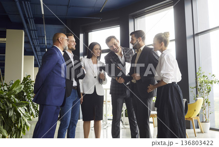 Business team meeting in modern open plan office, colleagues discussing strategy 136803422