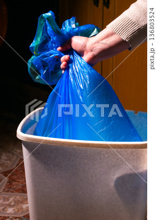 Woman taking garbage bag out of trash bin, closeup 136803524
