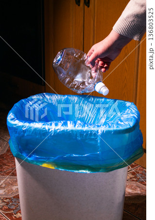Woman putting used plastic bottle in waste bin, separate waste collection and recycling concept. High quality photo 136803525