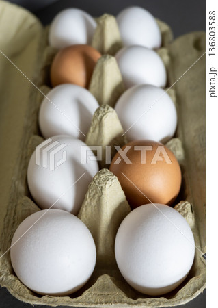 White and brown fresh eggs. Nature background. Chicken egg in carton box for cooking healthy food. Bio organic eggs on the farm. Food concept. 136803588