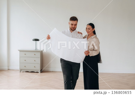 Reading the plan of room. Man and woman are indoors, conception of business 136803655