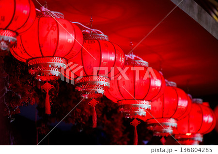 Vibrant red lanterns illuminate a festive night in a bustling street market Vibrant red lanterns illuminate a festive night in a bustling street market 136804285
