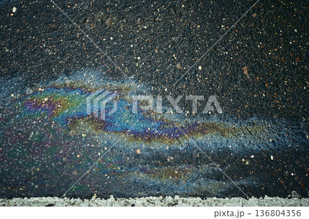 Colorful oil slick forming mesmerizing designs on the wet asphalt after rain Colorful oil slick forming mesmerizing designs on the wet asphalt after rain 136804356