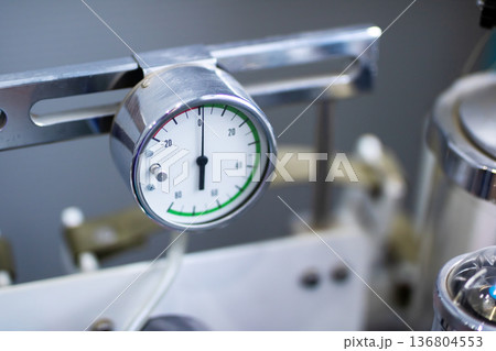 Closeup of stainless steel pressure gauge emphasizing calibration and maintenance environment 136804553