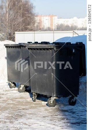 Snowy Courtyard with Waste Receptacles. Frozen Morning Scene Featuring Waste Containers in City Snowy Courtyard with Waste Receptacles. Frozen Morning Scene Featuring Waste Containers in City 136804572