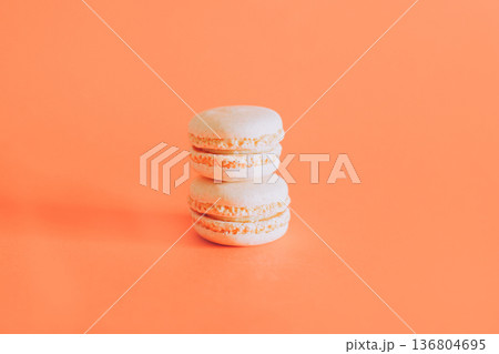 Tasty french macarons on a orange pastel background. Tasty french macarons on a orange pastel background. 136804695