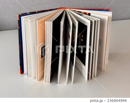 an open book standing on a table on a light background 136804994