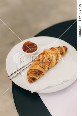 Tasty croissant with a jam on a table in a street cafe. Tasty croissant with a jam on a table in a street cafe. 136805719