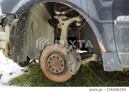 Close-up of old forsaken abandoned rusty broken trash car brake disc detail without rubber tire outdoors in field. Close-up of old forsaken abandoned rusty broken trash car brake disc detail without rubber tire outdoors in field. 136806289