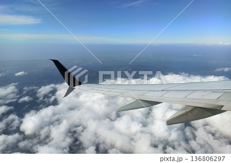 View through airplane window of commercial jet plane wing flying high in the sky. Air travelling concept View through airplane window of commercial jet plane wing flying high in the sky. Air travelling concept 136806297
