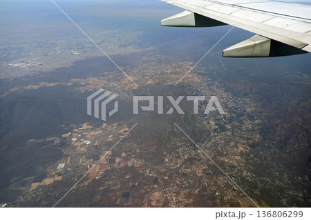 View through airplane window of commercial jet plane wing flying high in the sky. Air travelling concept View through airplane window of commercial jet plane wing flying high in the sky. Air travelling concept 136806299