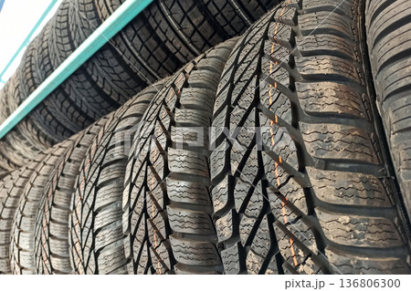 Many black rubber car tires on store shelf for sale. 136806300