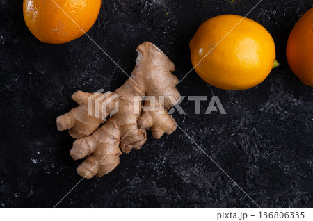 ripe beautiful lemons and ginger root at black table. flat lay. close up ripe beautiful lemons and ginger root at black table. flat lay. close up 136806335