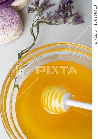 linden fresh honey with spoon and macaroons and herbs on white. macro. flat lay linden fresh honey with spoon and macaroons and herbs on white. macro. flat lay 136806413