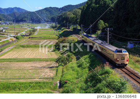 農閑期に入った田んぼの横を城崎に向け駆け抜ける山陰本線の特急列車 136806648