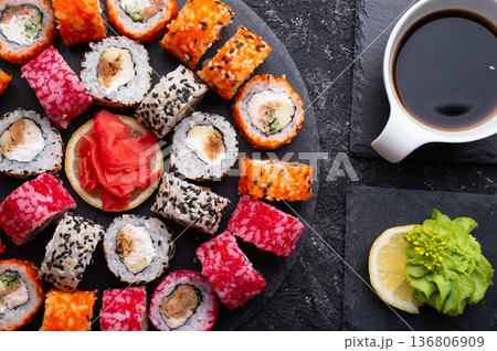 different sushi rolls set with fish beautiful served  at black dishes at black table. top view 136806909