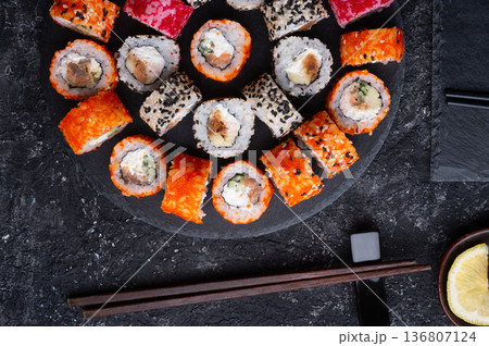 different delicious sushi rolls set with fish beautiful served at black dish at black table. flat lay. close up 136807124
