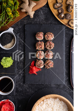 sushi roll with shiitake mushrooms served at black dish with rise at black table. flat lay sushi roll with shiitake mushrooms served at black dish with rise at black table. flat lay 136807249