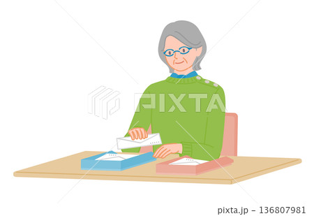 シニア女性が封筒をトレーに分ける整理作業 シニア女性が封筒をトレーに分ける整理作業 136807981