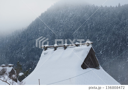 雪の美山のかやぶきの屋根と山 136808472