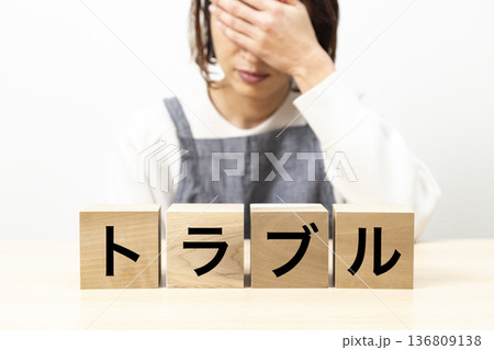 「トラブル」と書かれたブロックとエプロン姿の女性 136809138