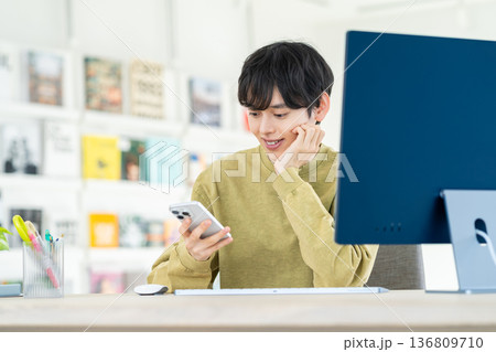 オフィスでスマホを使う若いデザイナー 136809710
