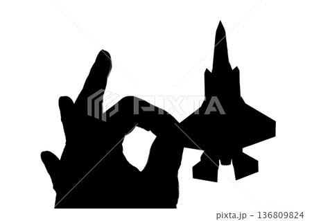 指でつままれたシルエットのジェット戦闘機 指でつままれたシルエットのジェット戦闘機 136809824