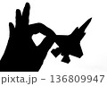 指でつままれたシルエットのジェット戦闘機 136809947