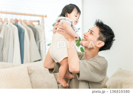 マイホームのリビングで赤ちゃん,娘を抱っこする父親,パパ,お父さん 136810380