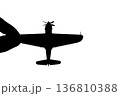 指でつままれたシルエットのプロペラ戦闘機 136810388