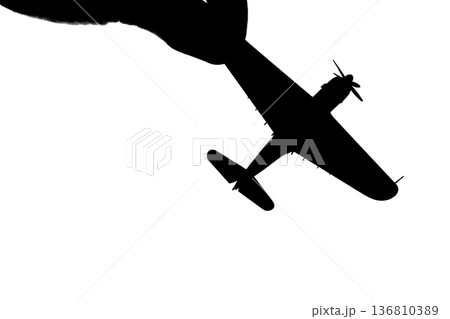 指でつままれたシルエットのプロペラ戦闘機 136810389