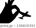 指でつままれたシルエットのプロペラ戦闘機 136810391