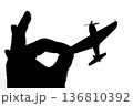 指でつままれたシルエットのプロペラ戦闘機 136810392