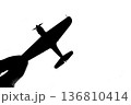 指でつままれたシルエットのプロペラ戦闘機 136810414