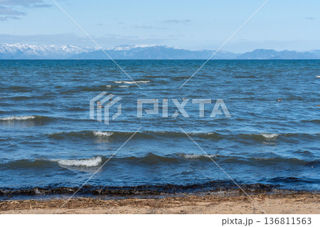 真冬の琵琶湖と遠く見える湖北の雪山の情景 136811563