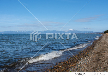 真冬の琵琶湖と遠く見える湖北の雪山の情景 136811567