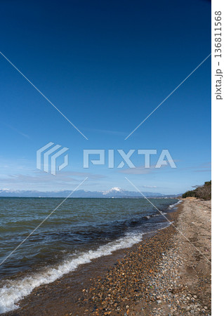 真冬の琵琶湖と遠く見える湖北の雪山の情景 136811568