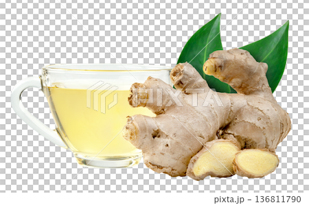 Fresh ginger root, slices, and green leaves next to a clear glass cup of hot herbal tea isolated. Healthy drink and natural remedy concept for wellness and immune support. 136811790