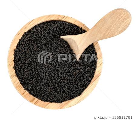 Top view of black basil seeds in a round wooden bowl with a wooden scoop. Healthy organic superfood, sabja seeds, isolated. Professional food photography for spice packaging. Top view of black basil seeds in a round wooden bowl with a wooden scoop. Healthy organic superfood, sabja seeds, isolated. Professional food photography for spice packaging. 136811791