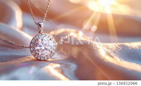 シルクの布の上で光り輝くダイヤモンドのネックレスと眩い光の玉ボケ 136812066