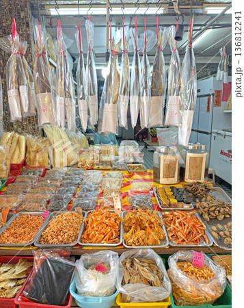 Abundant dried seafood and fish displayed at a bustling market stall in Asia Abundant dried seafood and fish displayed at a bustling market stall in Asia 136812241