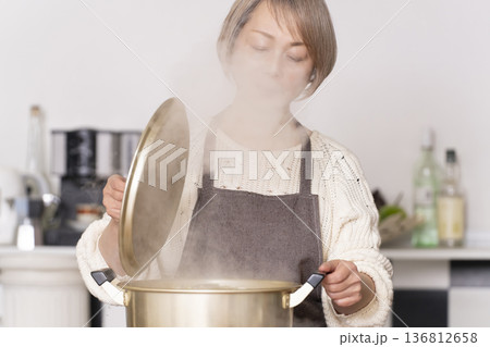 キッチンで豚汁を作りお椀に盛り付けるシニア女性 キッチンで豚汁を作りお椀に盛り付けるシニア女性 136812658