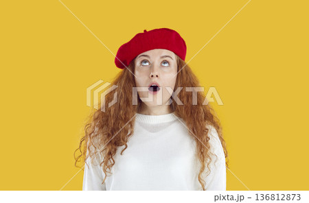 Young woman looking up with surprised and shocked expression, isolated on orange background. Young woman looking up with surprised and shocked expression, isolated on orange background. 136812873