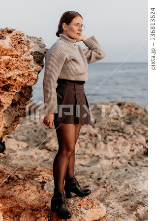 Woman Coastal Autumn Fashion: Stylish Outfit, Rocks, Sea, Fall Season, Trendy Look. 136813624