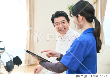 訪問介護でタブレットで管理をする介護士 136815573