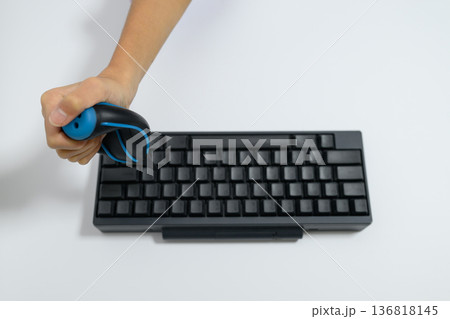 キーボードの埃をブロアーで掃除する人の手元 136818145