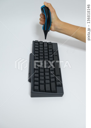 ブロアーを使ってキーボードを掃除する人の手元 ブロアーを使ってキーボードを掃除する人の手元 136818146
